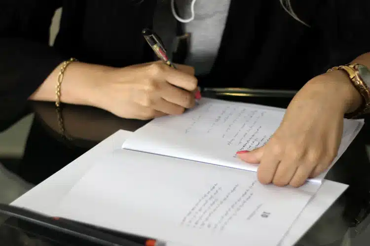 Image of a person writing on a document.